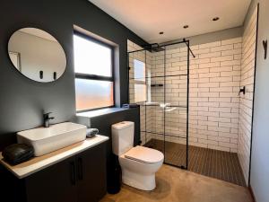 德尔斯特鲁姆Highland Gate Range View的一间带卫生间、水槽和镜子的浴室