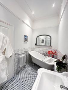 马伯斯View at 142的白色的浴室设有浴缸和水槽。