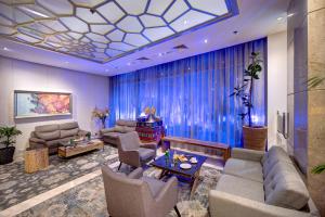 迪拜阿尔巴沙俊宏酒店的大型客厅配有蓝色窗帘和沙发