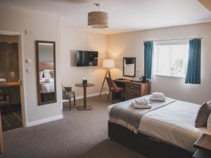 韦尔斯十字路口酒店的酒店客房带一张床、一张书桌和一面镜子