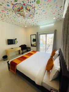 乌代浦Krishna kottage A Boutique Home Stay的一间卧室设有一张带色彩缤纷的天花板的大床