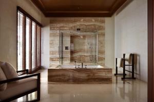 乌鲁瓦图宝格丽巴厘岛度假别墅酒店的一间带石墙浴缸的浴室
