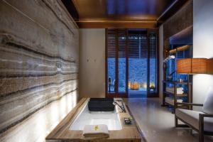 乌鲁瓦图宝格丽巴厘岛度假别墅酒店的一间带浴缸的浴室位于客房中间