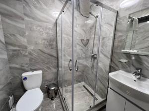 波尔塔瓦Yavir的带淋浴、卫生间和盥洗盆的浴室