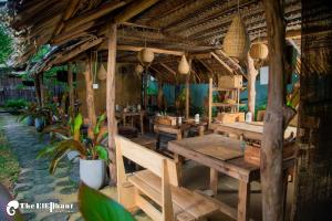 达瓦拉维The Elephant Next-Door的户外餐厅,设有木桌和盆栽植物