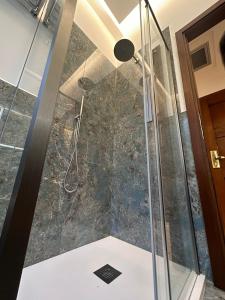 佛罗伦萨都方泰酒店的浴室里设有玻璃门淋浴