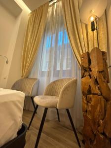 佛罗伦萨都方泰酒店的酒店客房窗户前的两把椅子