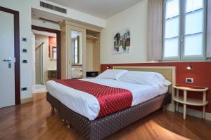 蒂拉诺Hotel Centrale Best Western Signature Collection的一间卧室设有一张红色墙壁的大床