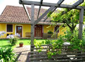 哈特贝格Landlust-Ferienhaus Am Rosenhof的一座黄色的小房子,设有木制凉棚