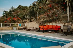 BethanyCruz Bay Tropical Condo的游泳池旁设有椅子和红色椅子
