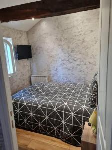 Saint-Germain-des-FossésPETIT GÎTE 18 ème tout confort的一间卧室设有一张床和石墙