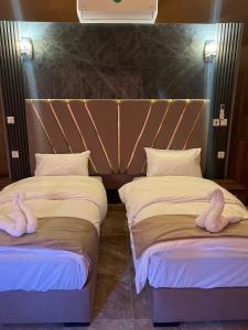 瓦迪拉姆Sand Star Camp的卧室内的两张床和天鹅毛巾
