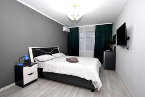 基希讷乌润特公寓的一间卧室配有白色床单和绿色窗帘