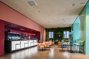 梅斯特CX Venice Mestre的餐厅拥有色彩缤纷的墙壁和桌椅