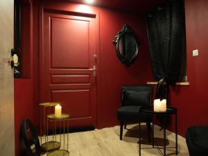 沙尔姆Douceur du Charme - Love-room à Charmes entre Epinal et nancy的红色的房间,设有红色的门、椅子和蜡烛