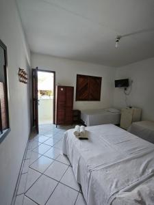 伊列乌斯Pousada Villa Graciela的卧室设有一张大床,铺有瓷砖地板。