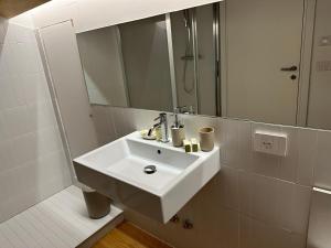 科马基奥Locanda del Delta的白色的浴室设有水槽和镜子