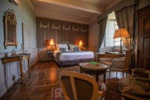 梅屈埃斯梅屈埃斯城堡酒店的卧室配有一张床和一张桌子及椅子