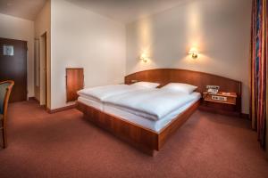 汉堡Hotel Alte Wache的一间卧室配有一张大床和木制床头板