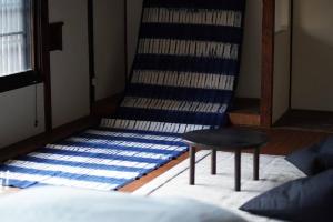しぼり染めが体験できる古民家宿MADO的一间设有桌子和条纹地毯的房间