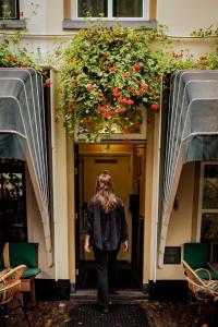 阿默斯福特Long John's Pub & Hotel的一位妇女走进一座花房