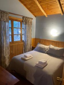 圣何塞德迈波Cabañas Parque Almendro的一间卧室配有一张床,上面有两条毛巾