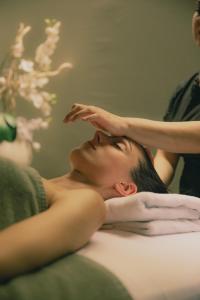 加尔达湖滨Astoria Resort的一位手放在头上躺在床上的女人