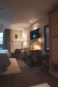 韦姆德范戈比洛斯酒店的一间卧室配有一张床和一张桌子及椅子