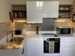 萨弗伦沃尔登Enchanting 1 Bedroom Home with Kitchen的厨房配有白色橱柜、水槽和微波炉