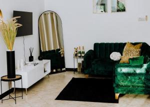 达累斯萨拉姆LM Apartments的客厅配有绿色沙发和镜子