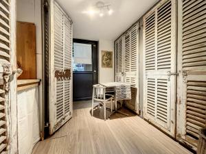 斯特拉斯堡Petit Nid的客房设有木制百叶窗和桌椅。