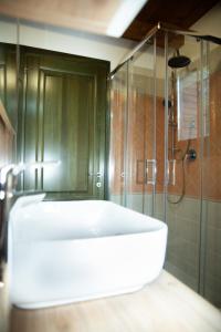 帕武洛内尔夫里尼亚诺B & B CA’ D’ OLINA的浴室配有白色浴缸和淋浴。