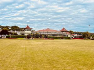 Port BannatyneBeautiful spacious old schoolhouse with stunning sea views and beach nearby的大型建筑前方的大型草地