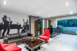 波哥大爵士公寓酒店的客厅配有真皮沙发和红色椅子
