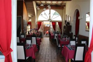 Azay-le-Ferron特里布里恩酒店的一间餐厅,房间内设有红色的桌椅