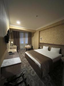 巴库Royal Boutique Baku的酒店客房设有一张大床和一张书桌。