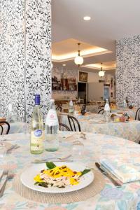 里米尼Hotel Centrale Miramare的一张桌子上放着一盘食物和瓶子