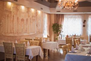 第聂伯罗韦莱斯酒店 的一间带桌椅和吊灯的用餐室