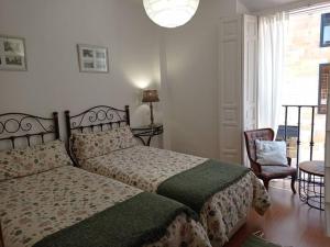 奥维多Alojamiento Oviedo 1的卧室配有床、椅子和窗户。