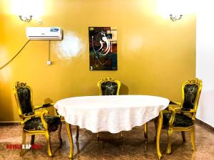 FoumbanHôtel appartement luxe的一间配备有白色桌子和四把椅子的用餐室