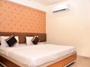 艾哈迈达巴德Hotel Bharosa inn Naroda的一间卧室配有一张带白色床罩的大床