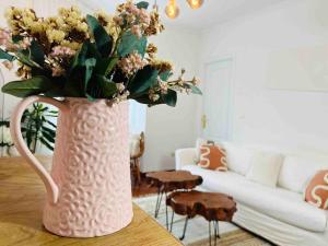 维戈Apartamento Vigo Parking Gratuito的客厅里一张桌子上花的粉红色花瓶