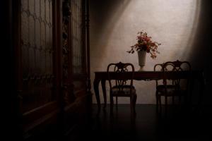 乌尔比诺Palazzo Giusti Suites and Spa的一张桌子,花瓶和两把椅子
