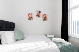 哈特尔普尔Bright House的卧室配有一张墙上三幅照片的床