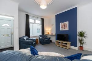 哈特尔普尔Bright House的客厅设有蓝色的墙壁和电视。