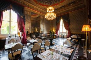 佛罗伦萨科拉别墅酒店的一间带桌椅和吊灯的用餐室