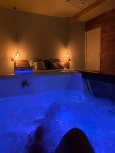 MarlhesSuperbe appartement avec jacuzzi et jardin privé的床上的蓝色浴缸