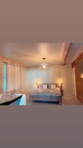 MarlhesSuperbe appartement avec jacuzzi et jardin privé的卧室配有床和盥洗盆