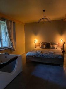 MarlhesSuperbe appartement avec jacuzzi et jardin privé的一间卧室配有一张床和一个浴缸
