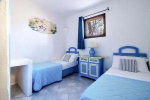 巴哈撒丁岛Residence I Cormorani Bis的蓝色和白色的客房内的两张床